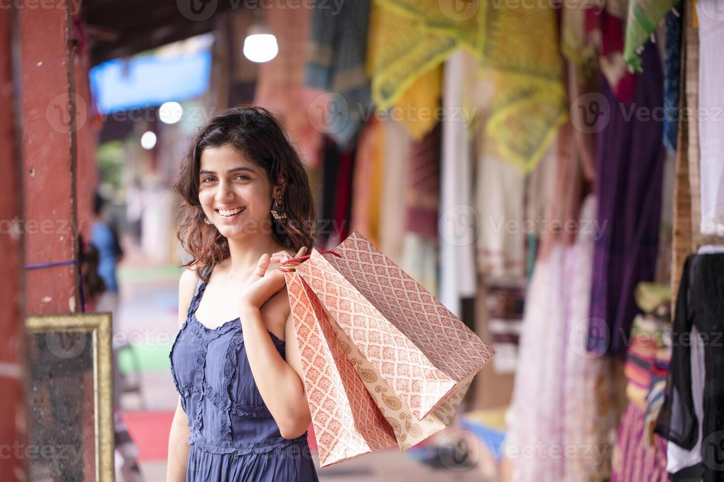 Blond Woman Holding Shopping Bags While Looking At Camera photo