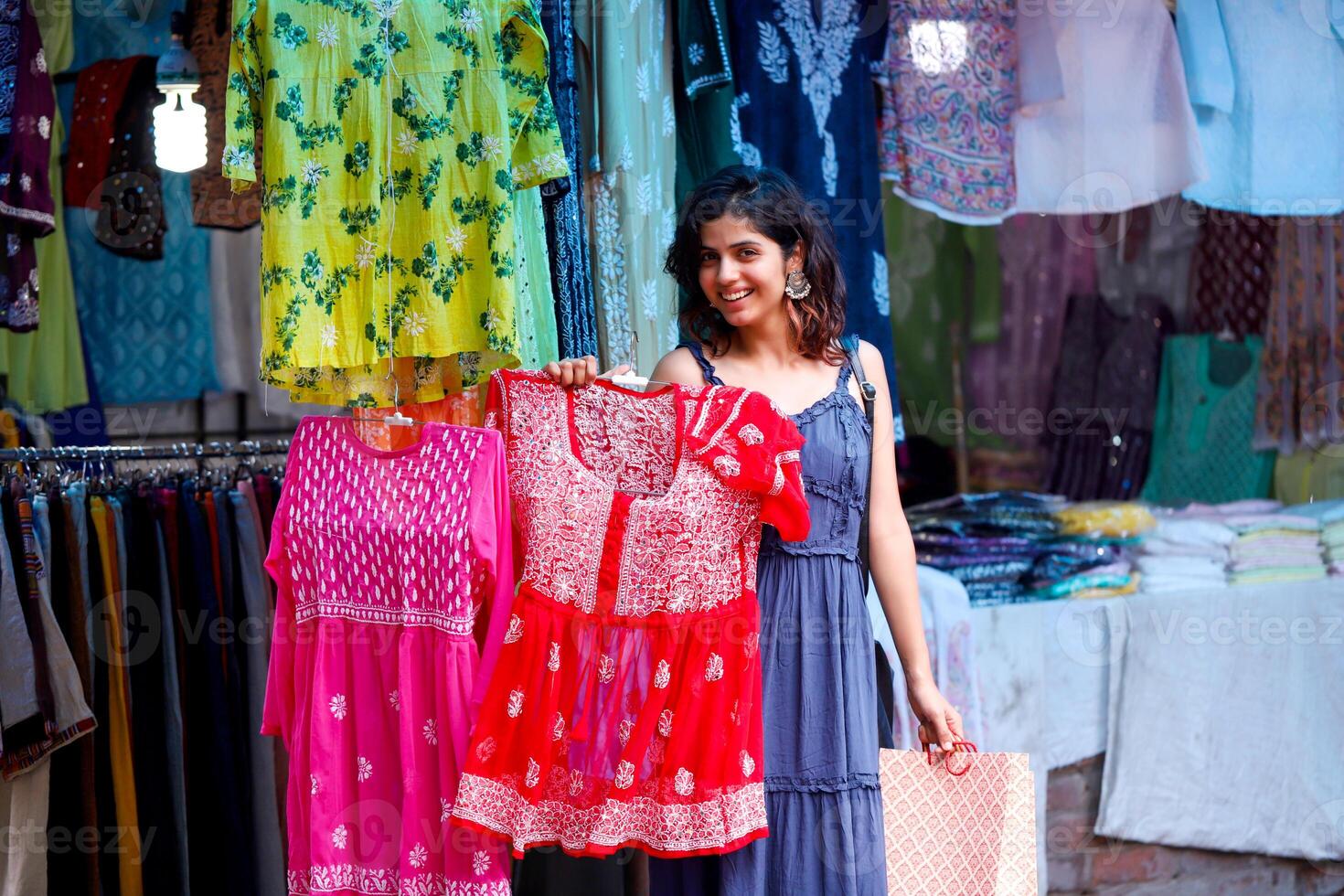 Hot And Sexy Woman Displaying Red Colour Lakhnavi Top In Hand While Looking At Camera photo