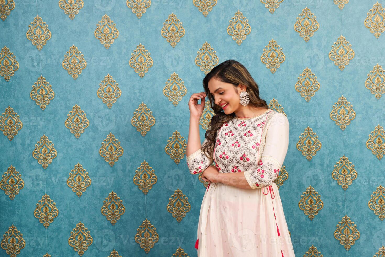 A Shy Woman Covering Her Face With Her Hand While Posing Against The Wall photo