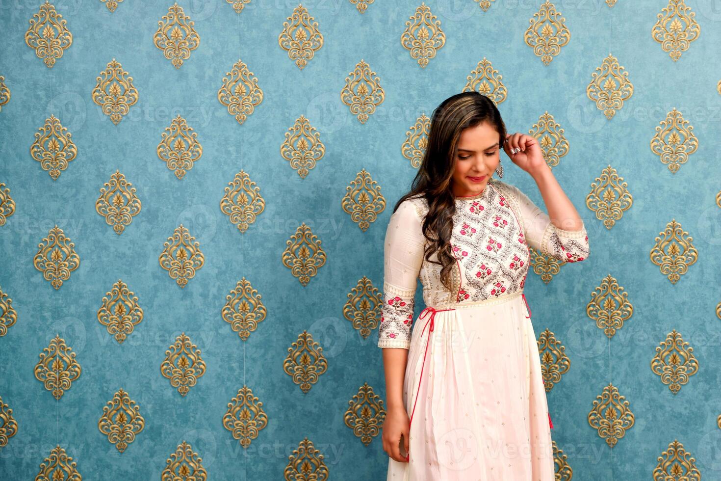 A Shy Model Is Blushing And Posing While Looking At The Floor photo