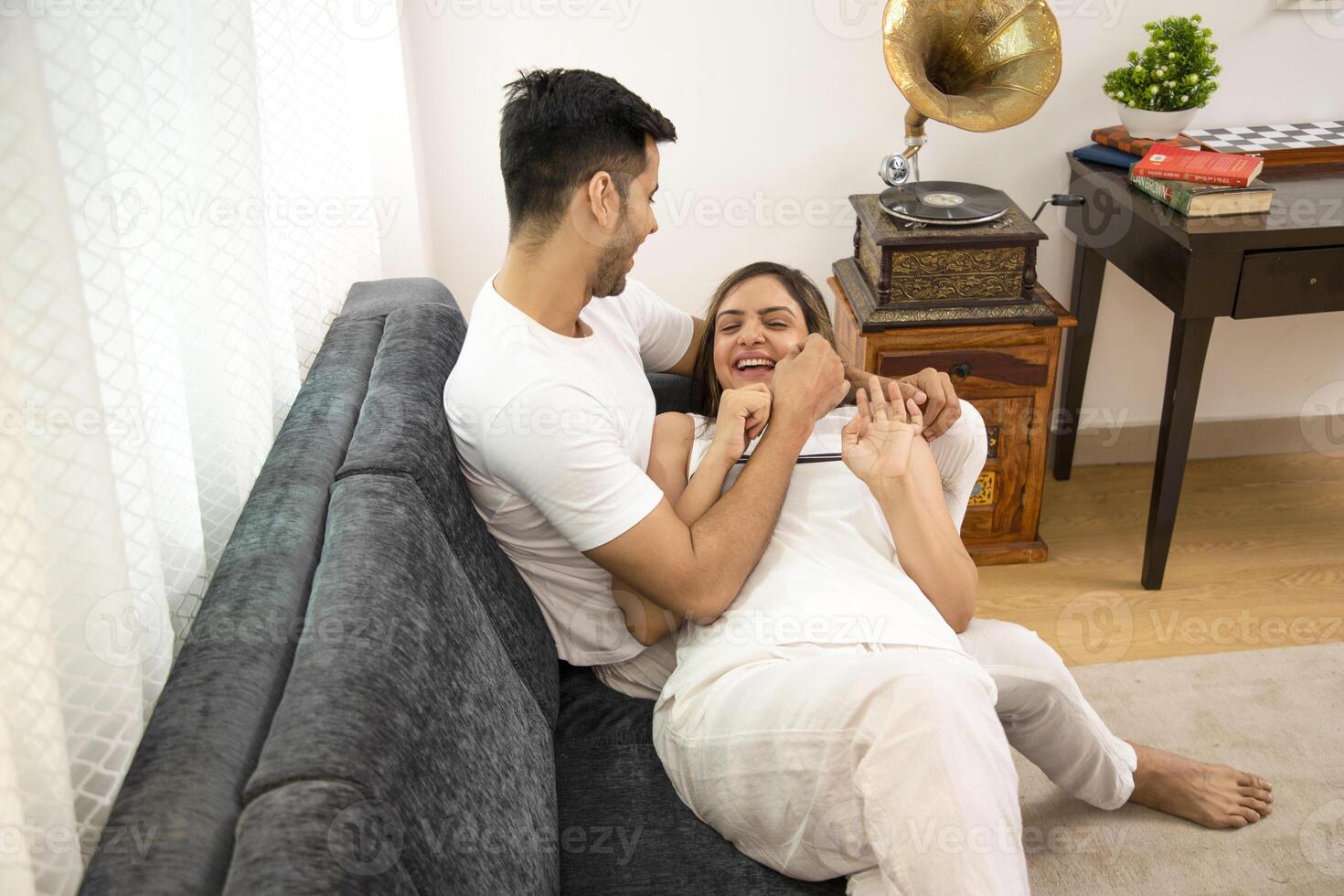 Adorable Couple Smiling And Husband Is Pulling Cheek Of His Wife photo