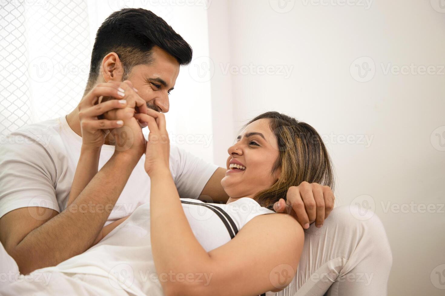 Married Couple Smiling And Looking At Each Other While Holding Hands photo
