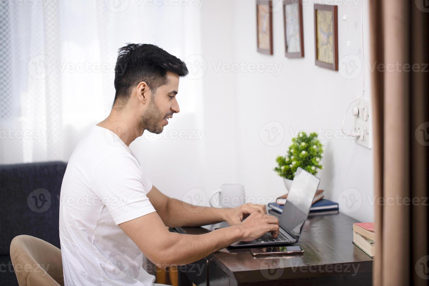 Man Using Laptop While Working At The Home Office photo