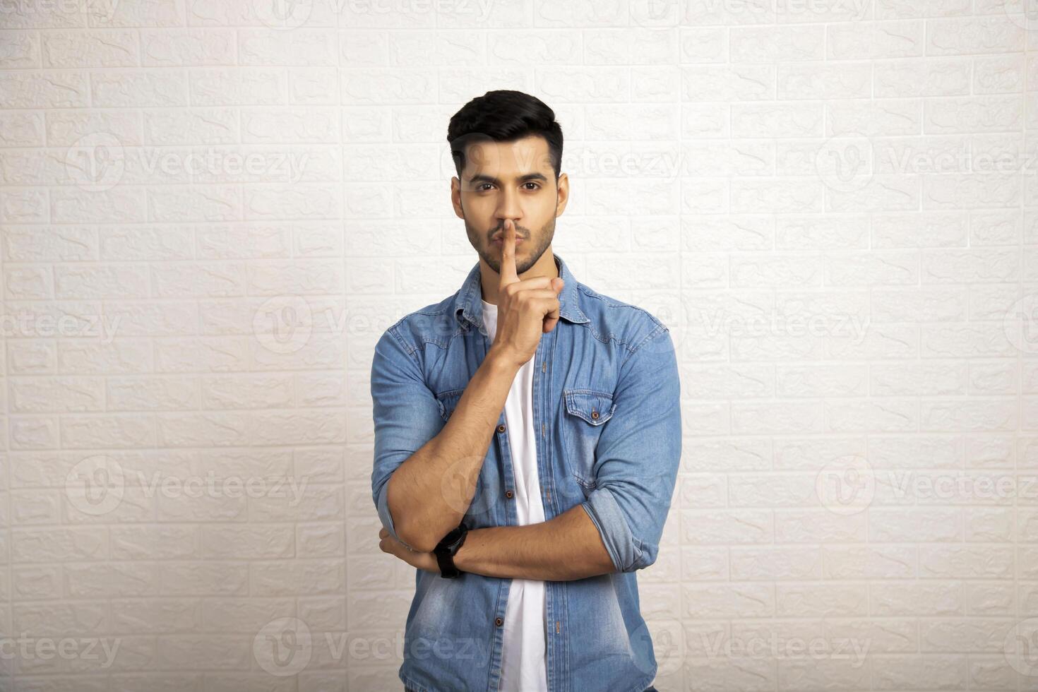 Brunette Male Model With Finger On Lips photo