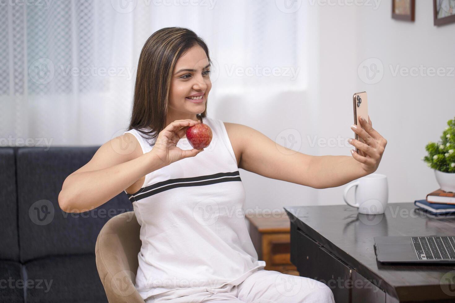 Asian Cute Woman In White Outfit Showing Apple On Call photo