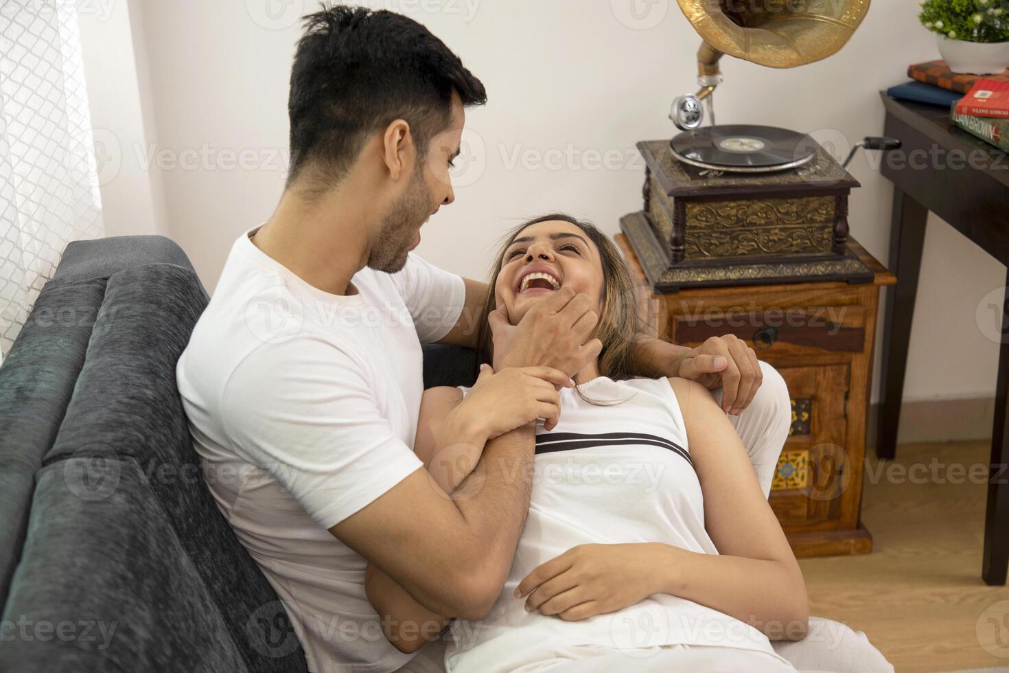 Picture Of Couple In Love In White Outfit Sitting On Couch photo