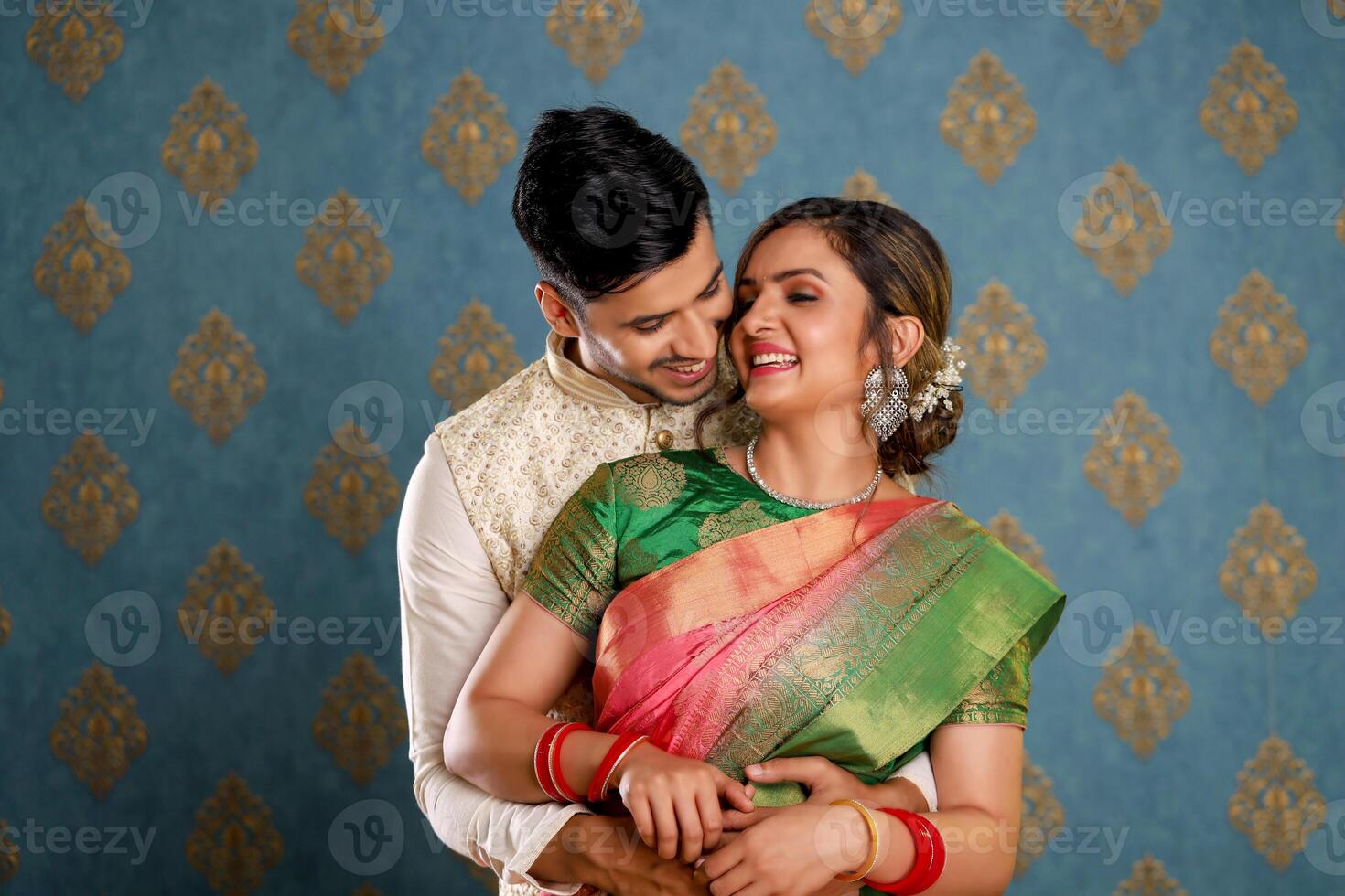 Cute Love Couple In Traditional Outfits Standing Hugging In Front Of The Camera photo