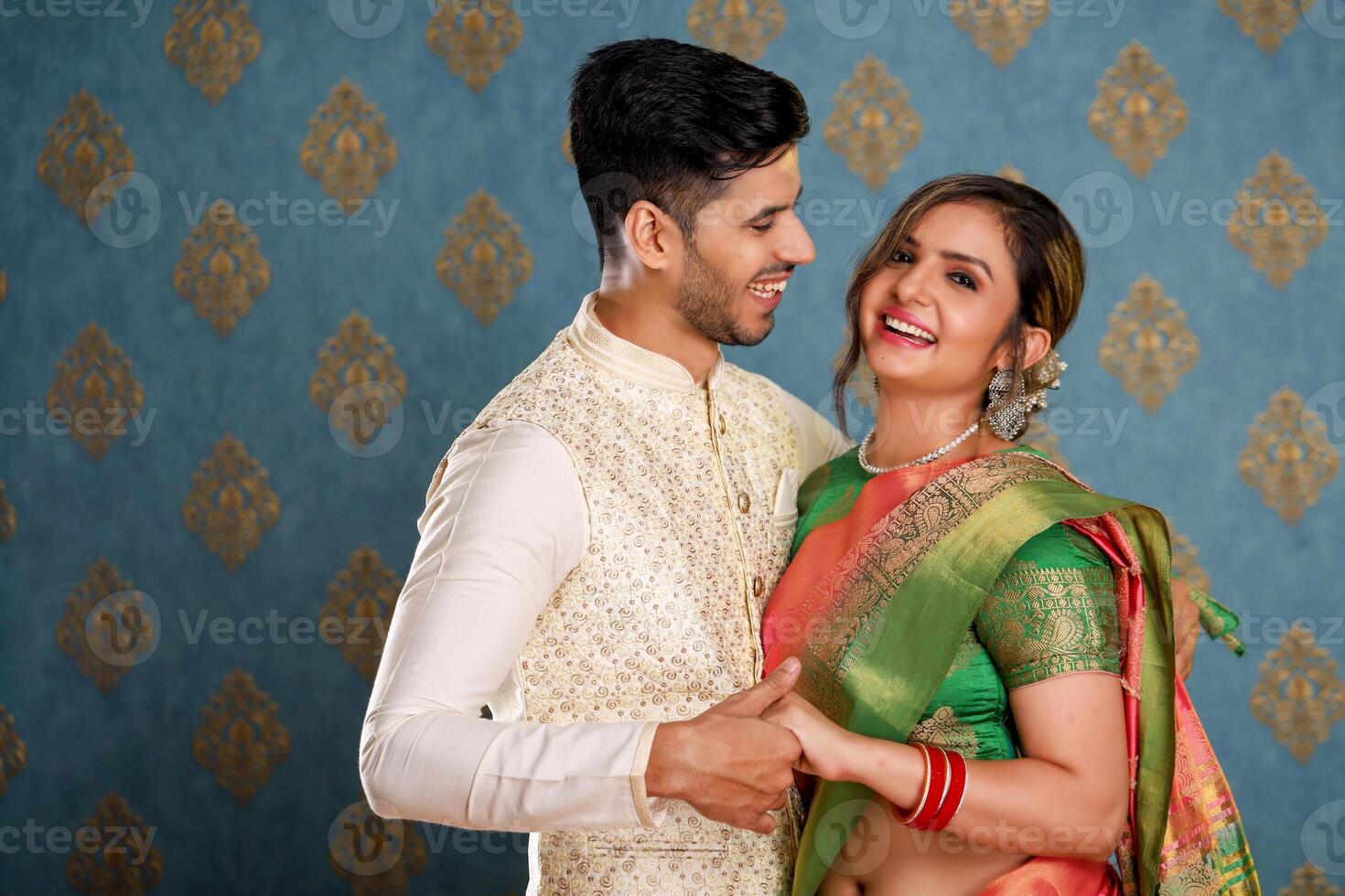 Happy Beautiful Couple In Traditional Outfits Standing And Holding Hands photo
