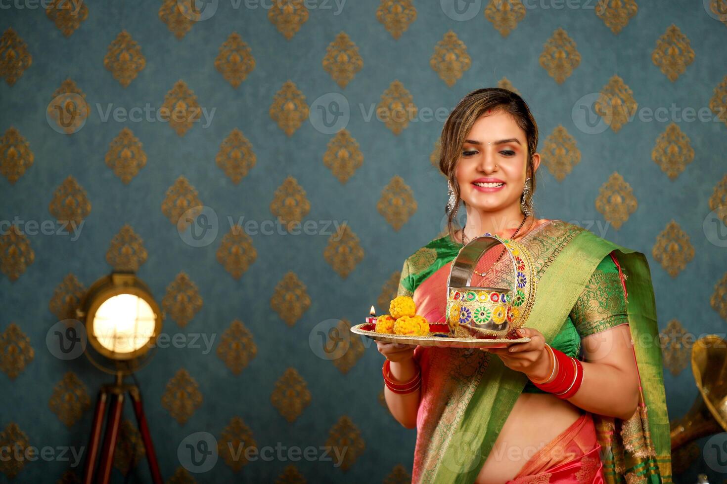Image Of Model Smiling In Saree While Holding Puja Plate During Karwa Chauth Festival photo