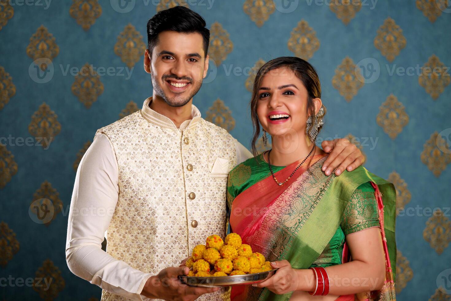 Image Of Loving Couple Holding Plate Of Ladoo During Diwali Festival photo