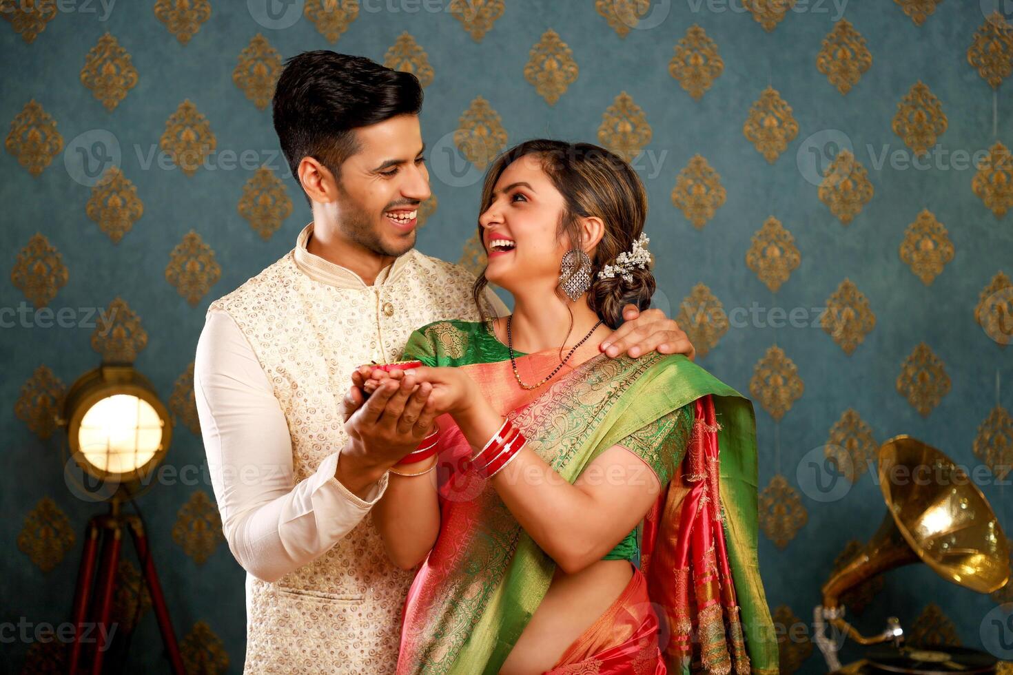 Beautiful Couple In Indian Traditional Clothing Posing With Diya In Front Of Camera. photo