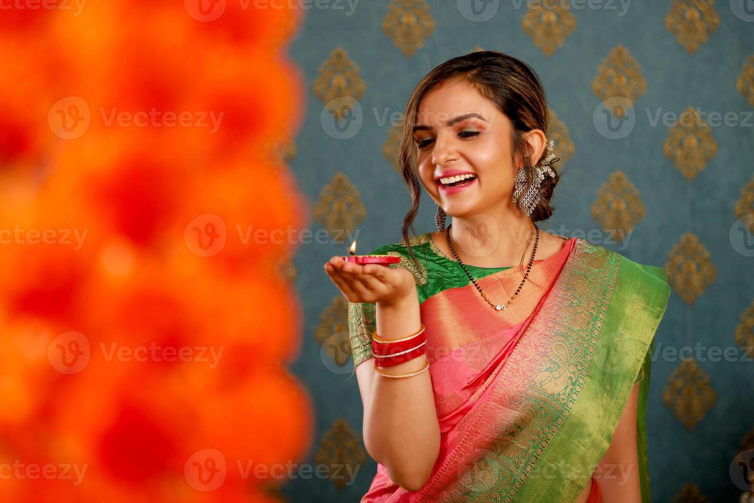 Attractive Lady In Saree Posing For Camera While Holding Diya In Hand photo