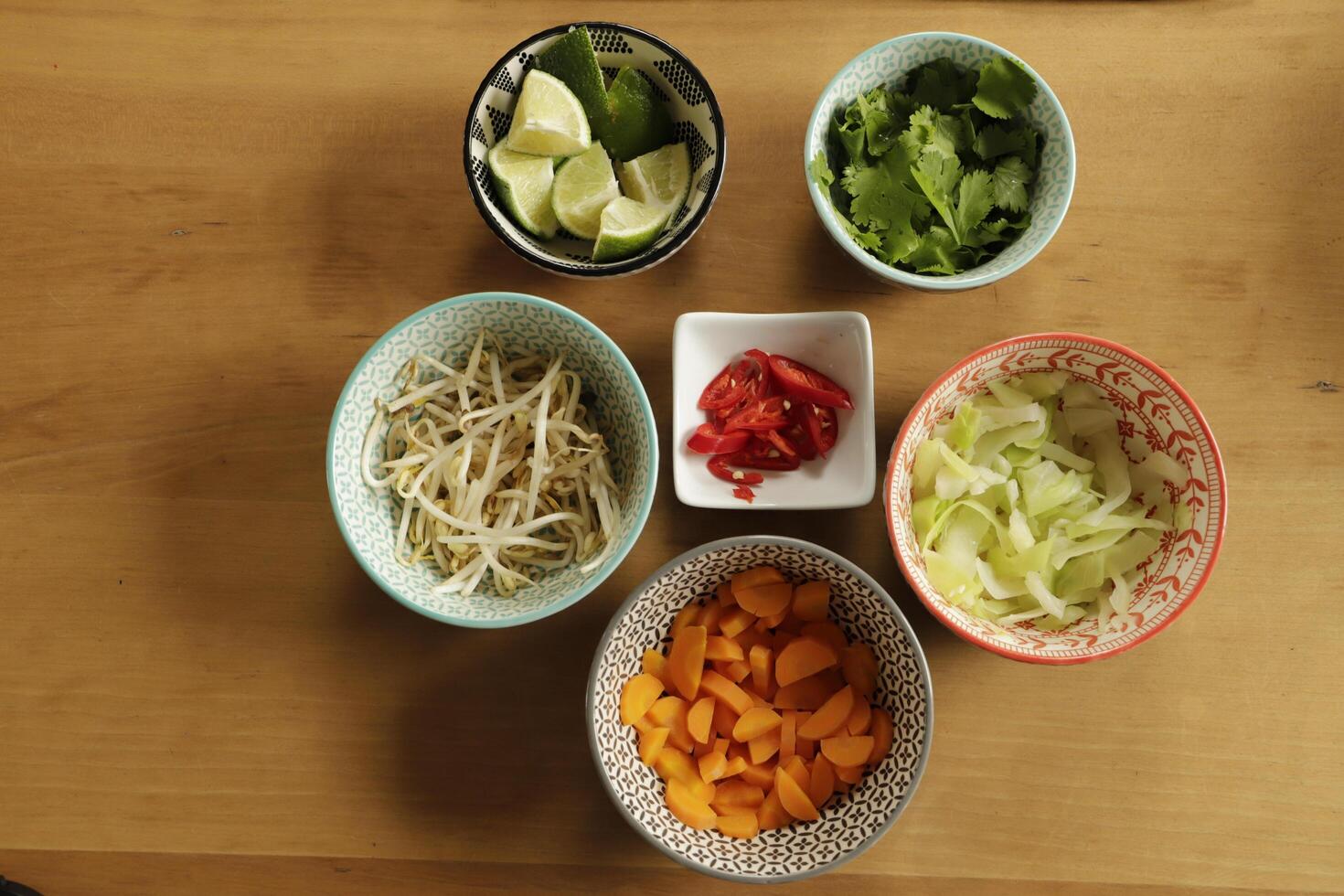 ingredients to cook asian soup, bean sprouts, carrots, cabbage, chili pepper, lime, coriander photo