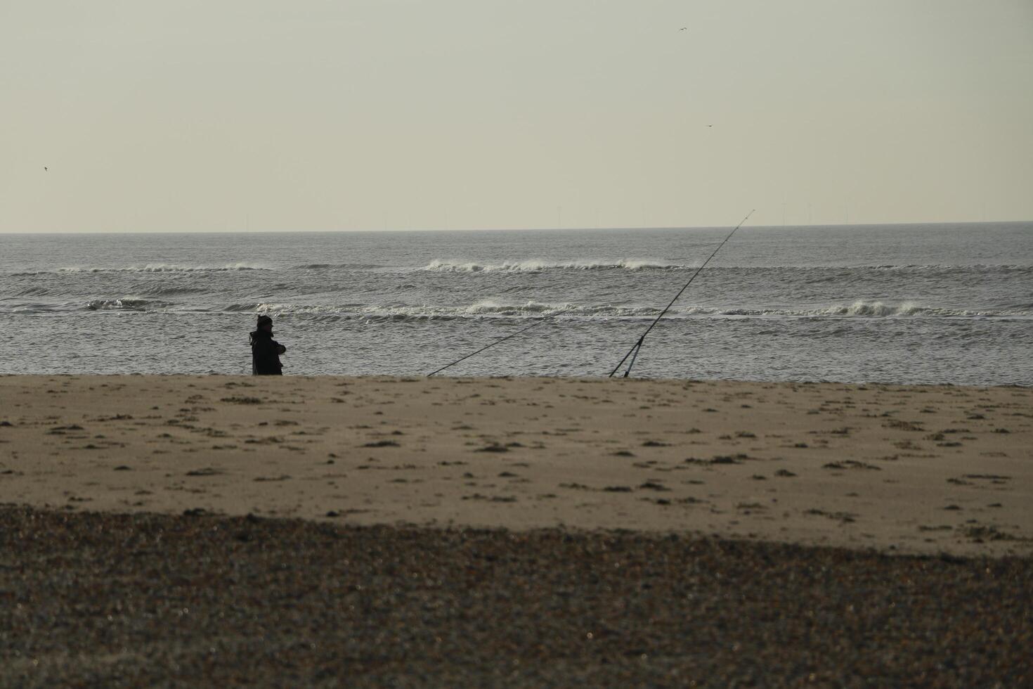 fisherman, beach in the winter, netherlands photo