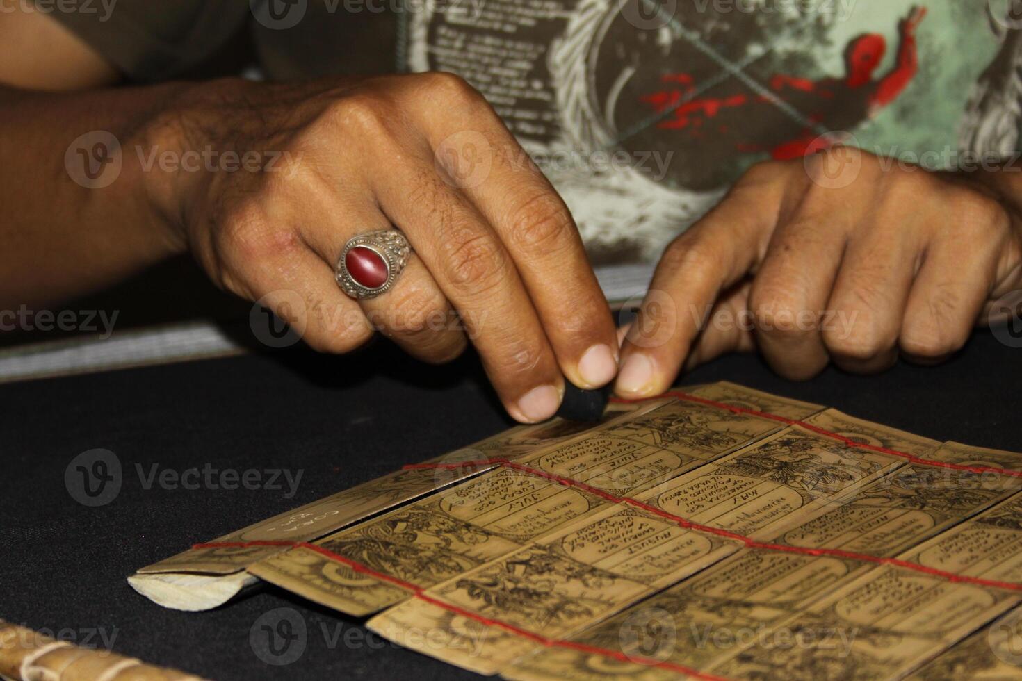 Making a balinese calender with bamboo and charcoal, Tenganan a traditional balinese village, Balinese Aga the original inhabitants of the island, photo