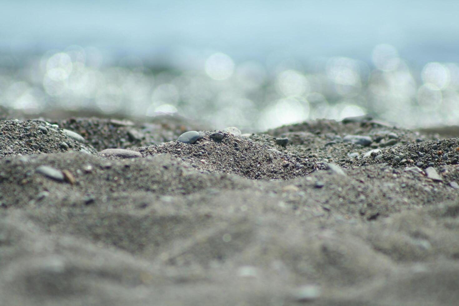 sand on the beach, blurry water photo