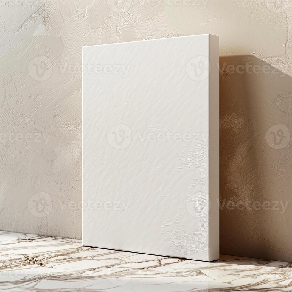 A blank canvas stands on the marble floor, leaning against a beige concrete wall with a subtle striped texture. photo
