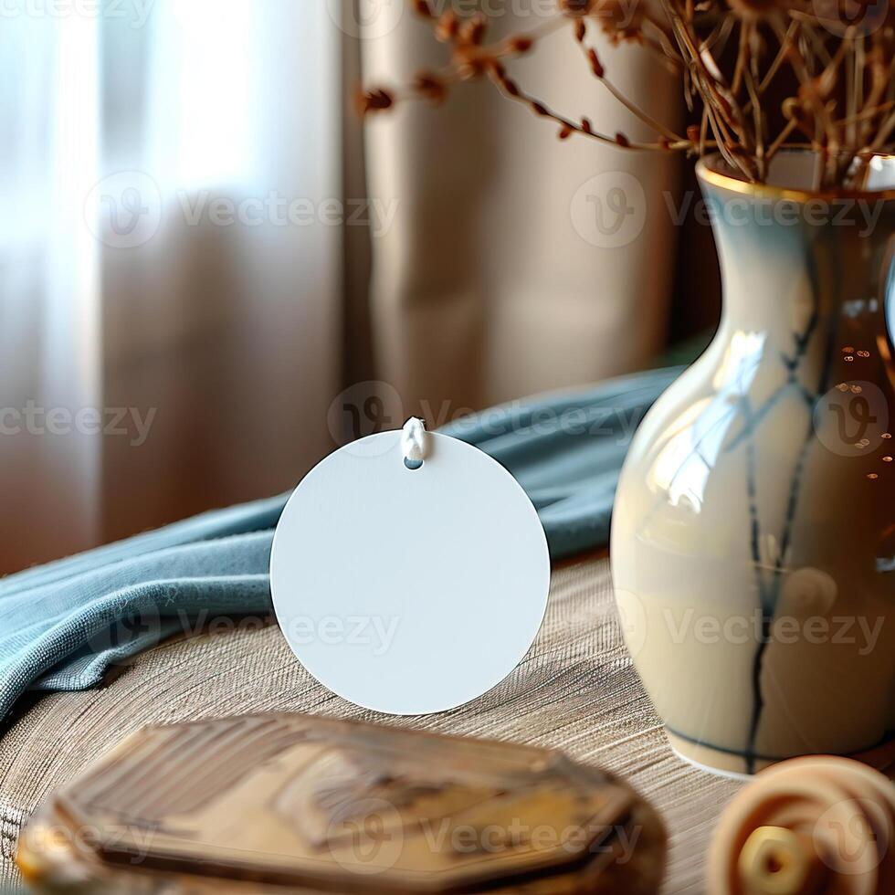 An empty round tag with a hole at the top hangs on a table. photo
