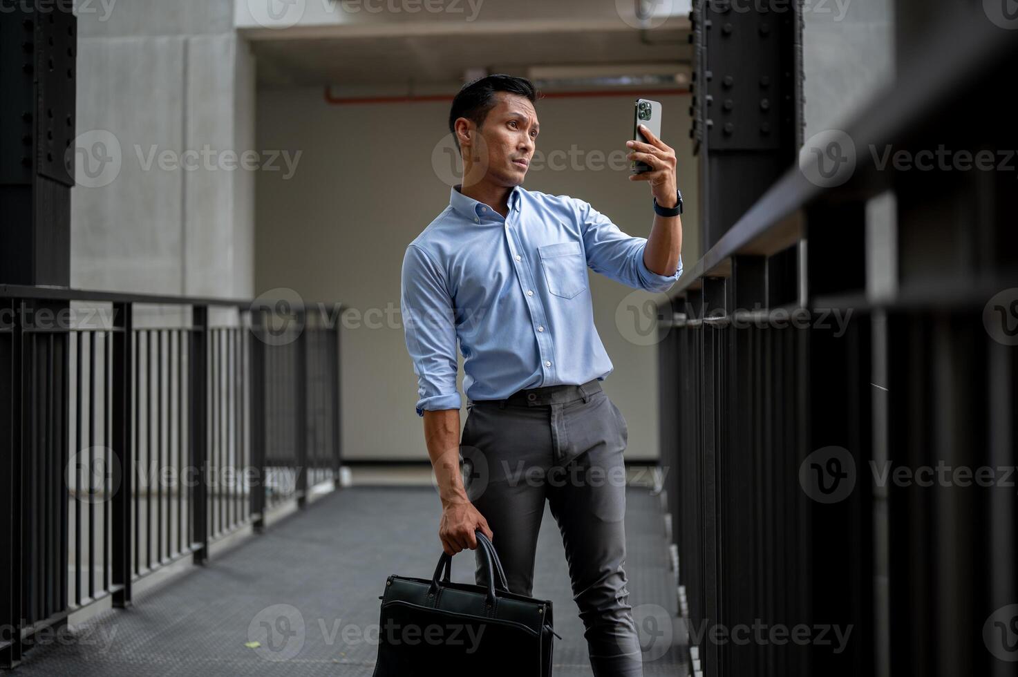 A businessman looking at his phone screen with a confused expression, searching for phone signal. photo