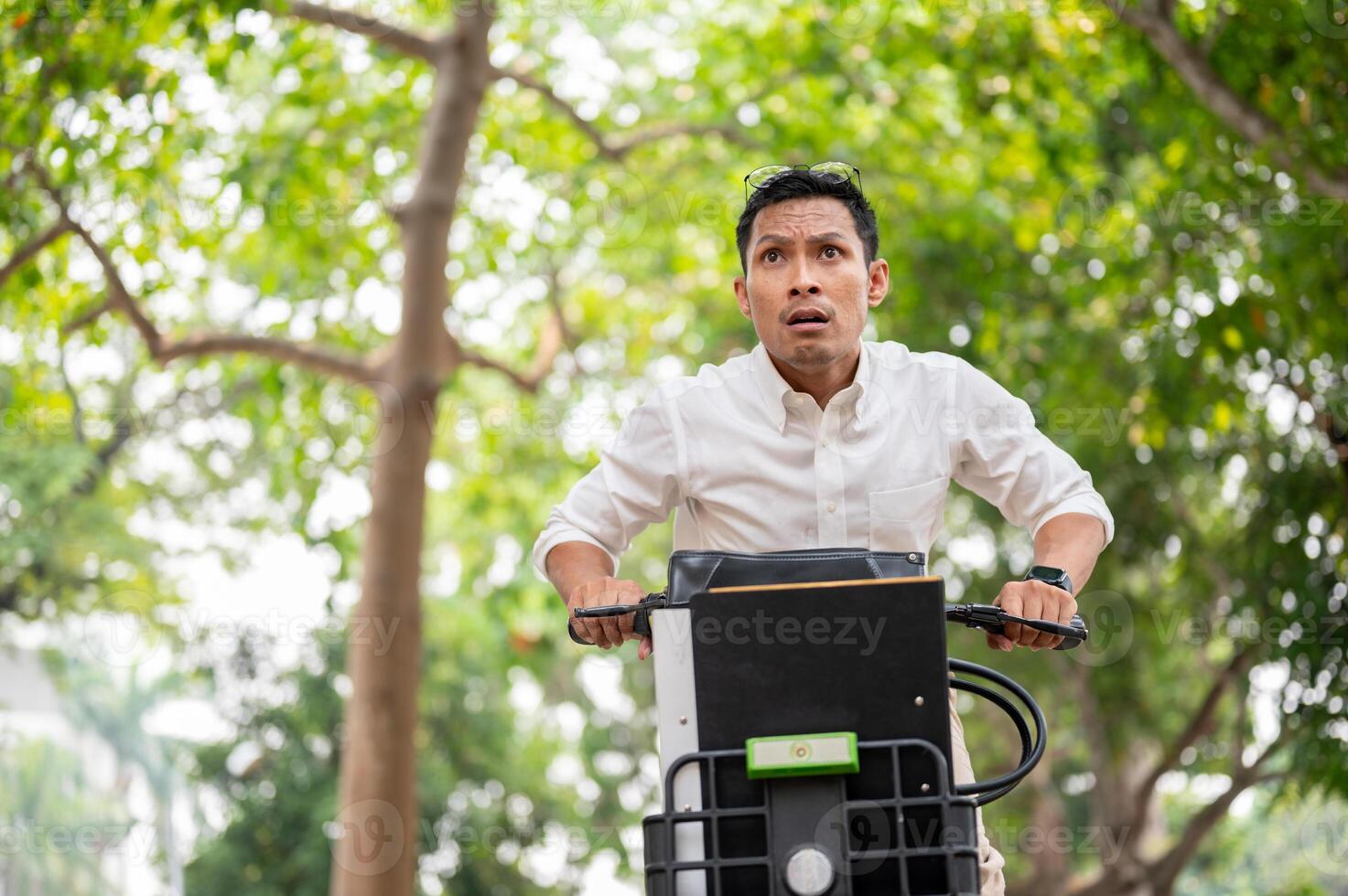 An anxious Asian businessman is in a hurry to get to work in the morning, riding a bike. photo