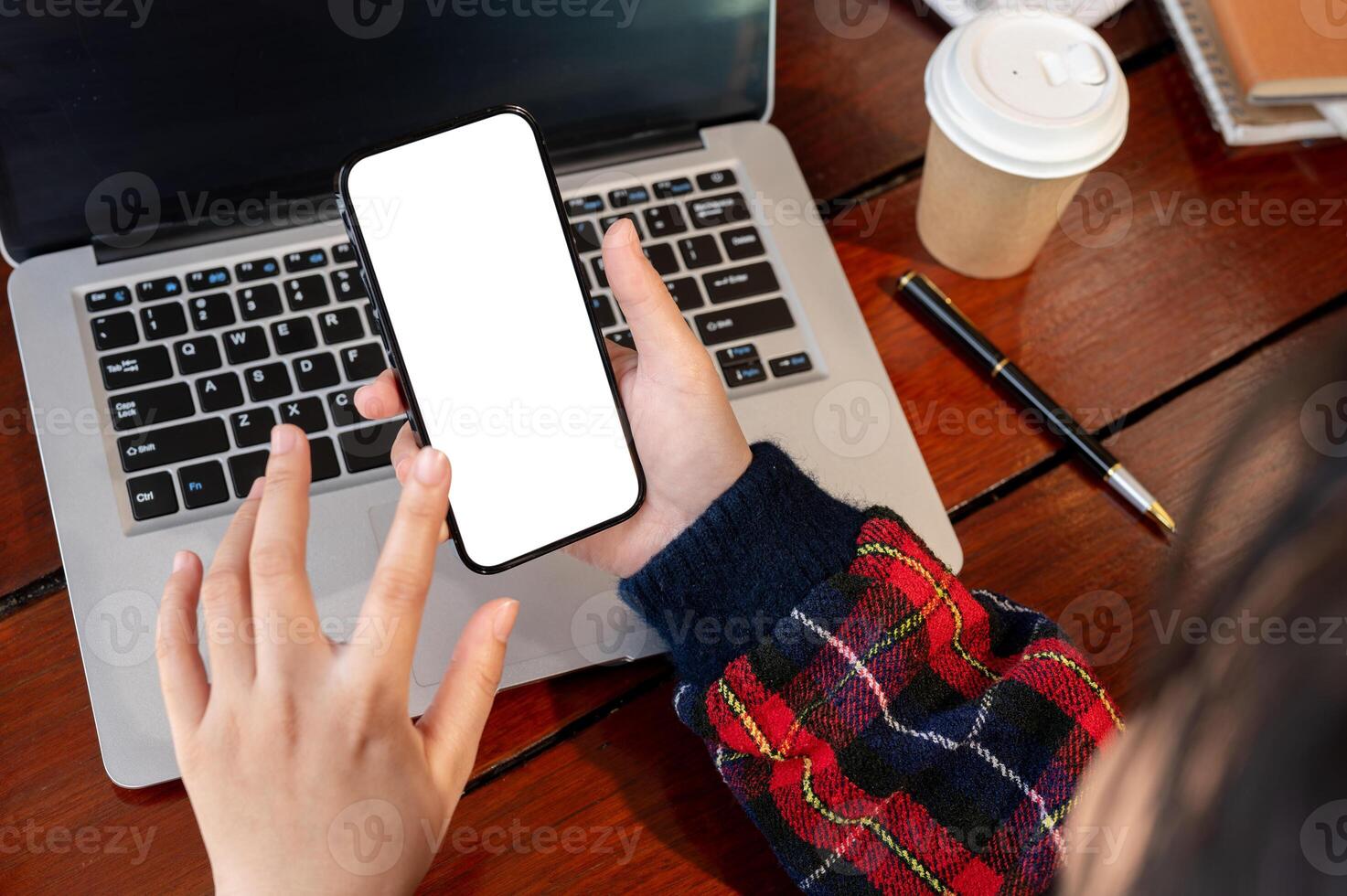Close-up image of an Asian woman using her smartphone at her work desk. photo