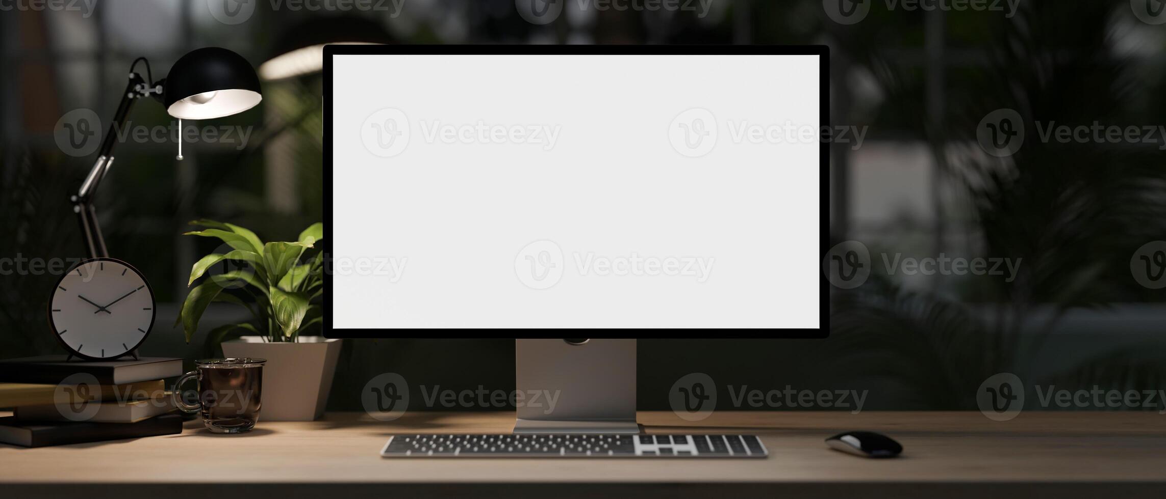 A modern home office desk at night with a white-screen computer mockup, dim light from a table lamp. photo