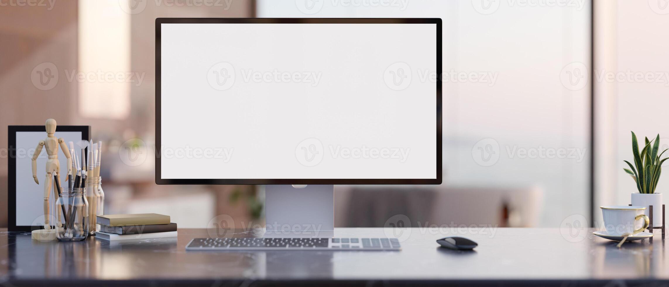 A modern office features a white-screen computer mockup and accessories arranged on a table. photo