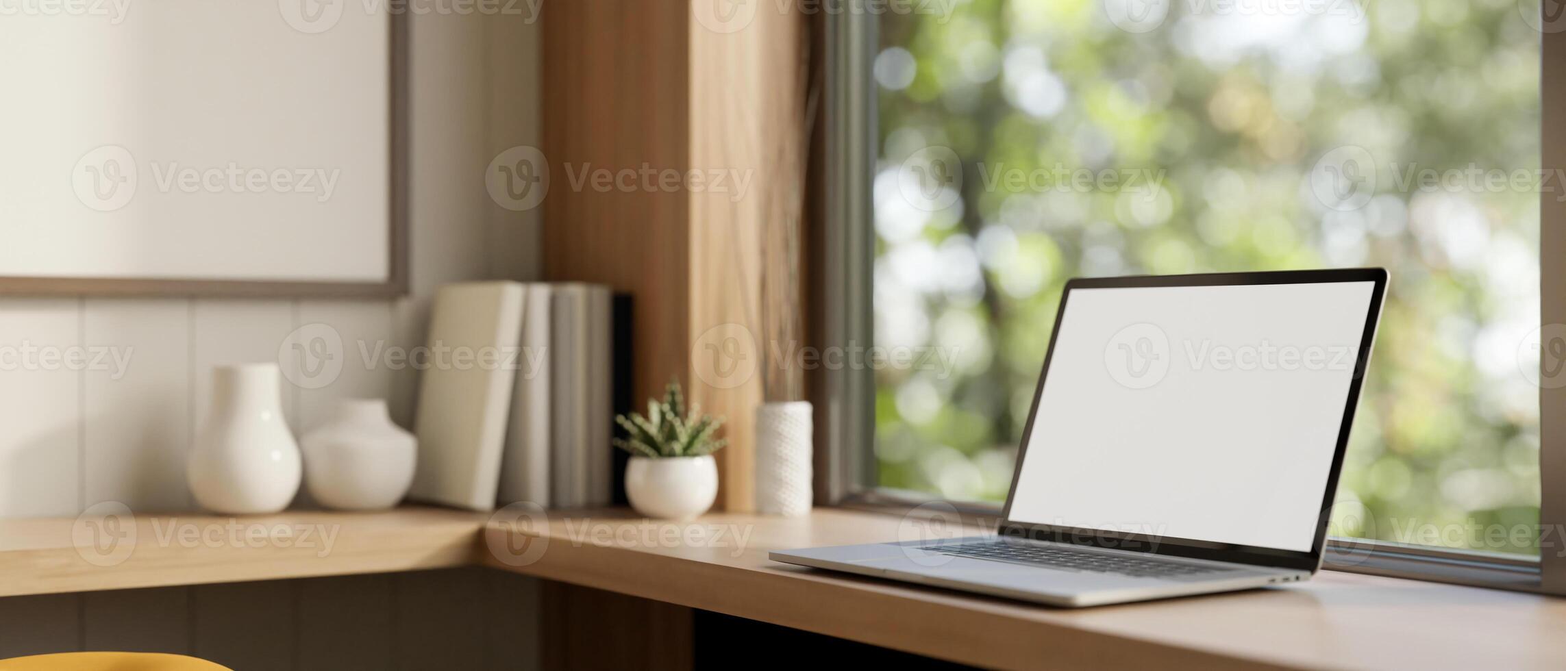 A white-screen laptop computer on a wooden table against the window in a modern Scandinavian room. photo