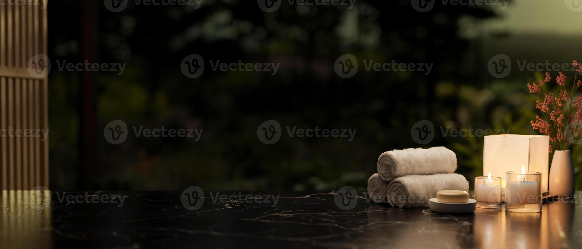 A copy space on a black marble table featuring towels, candles, a soap, and a lamp in a dark room. photo