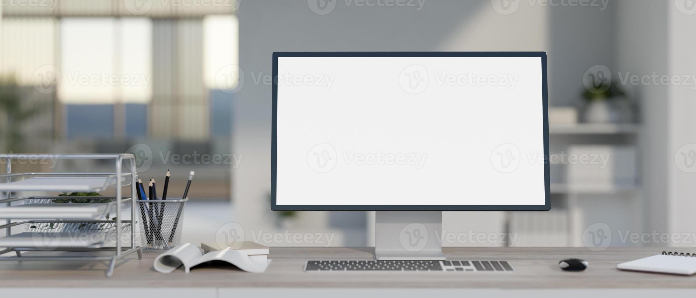 A modern, bright office with a white-screen computer mockup and office supplies on the desk. photo