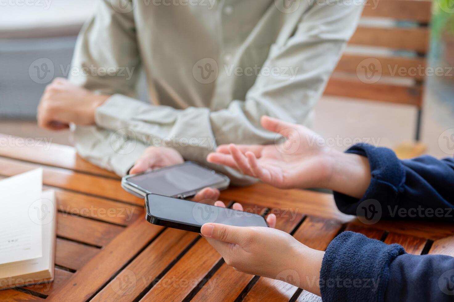 Two people sharing contact info or transferring files by bringing two smartphones close together. photo