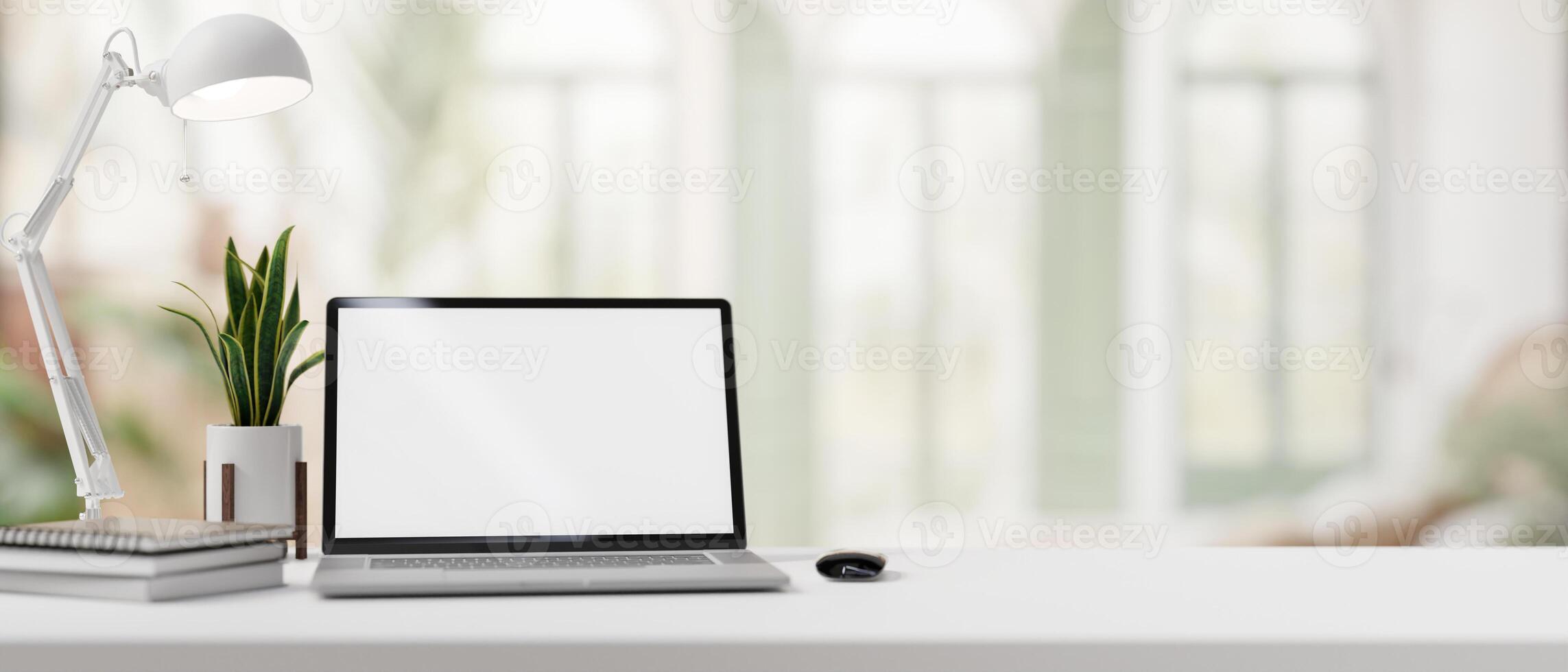 A desk with a laptop mockup set against the blurred background of a modern home office. photo
