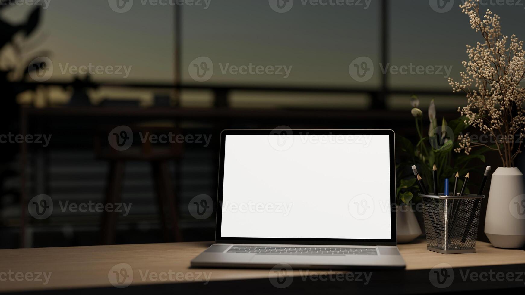 A laptop computer mockup on a wooden desk in a contemporary dark co-working space at night. photo