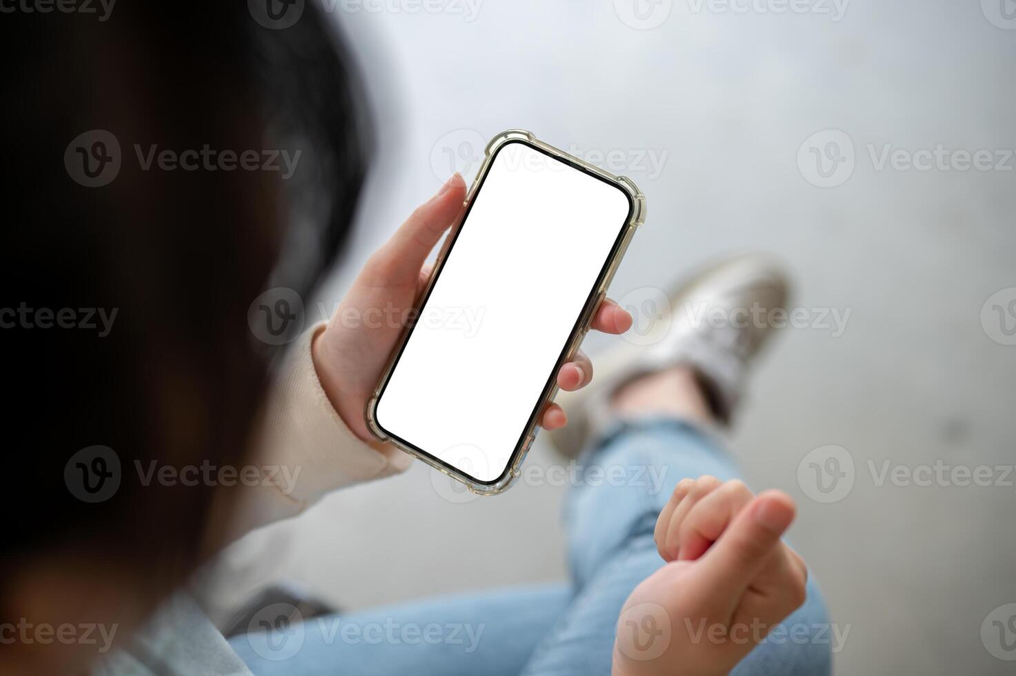 An angry, unhappy woman showing her clenched fist while using her smartphone, sitting indoors. photo