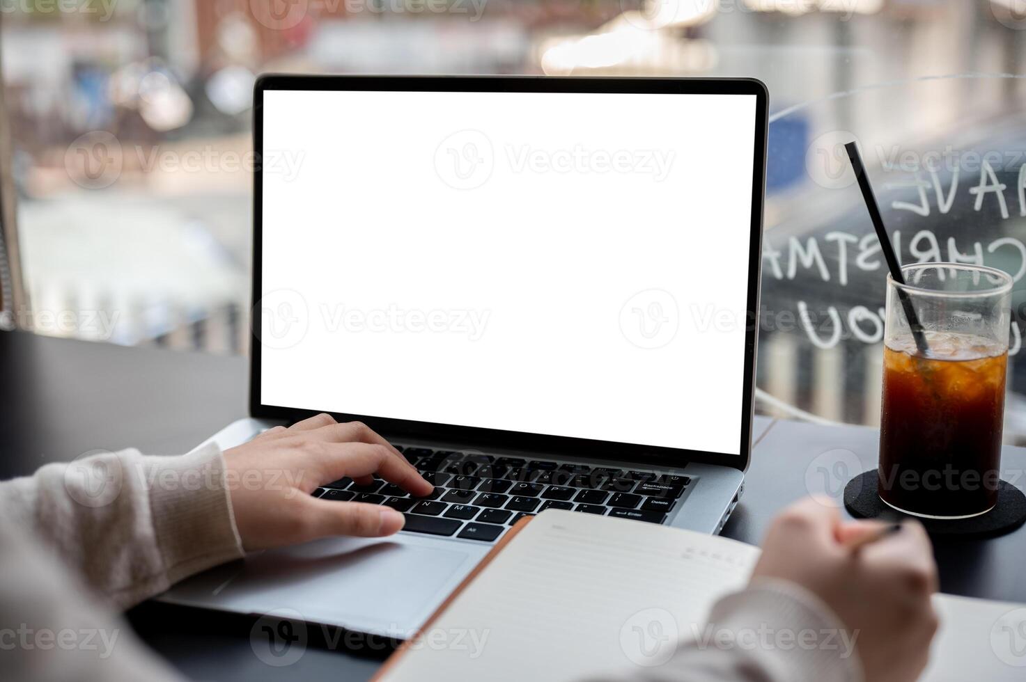 A close-up image of a college student studying online on her laptop computer at a coffee shop. photo