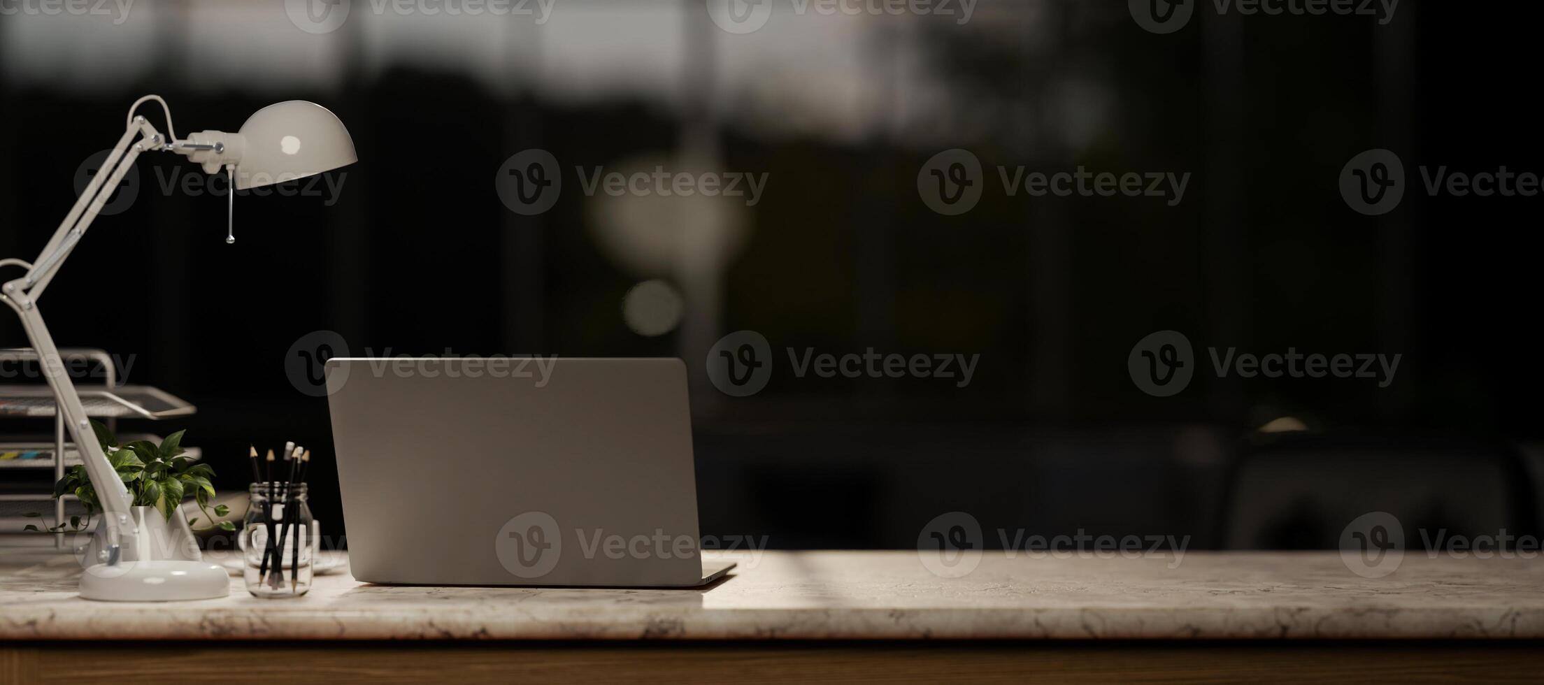 A laptop computer on a marble table in a modern dark office at night. photo