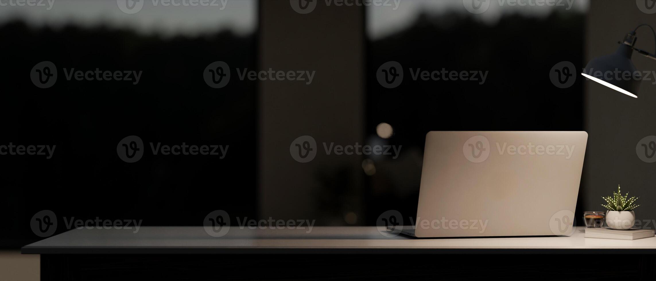 A back view image of a laptop computer on the table in a modern, dark room at night. photo
