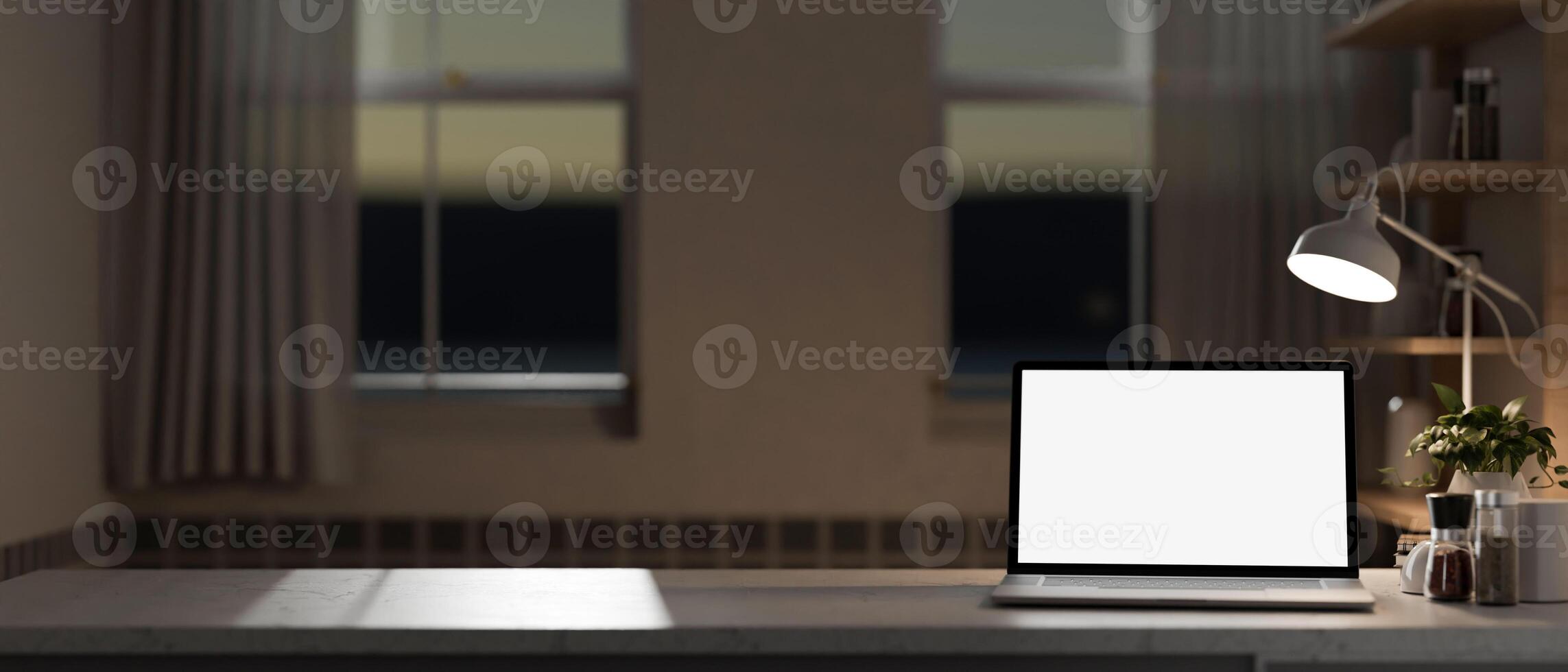A home office workspace with a white-screen laptop computer mockup on a table in the evening. photo
