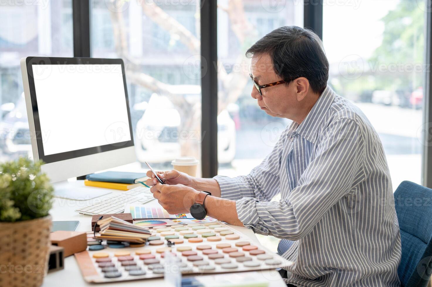 An experienced Asian male interior designer or architect is working on his project in the office. photo