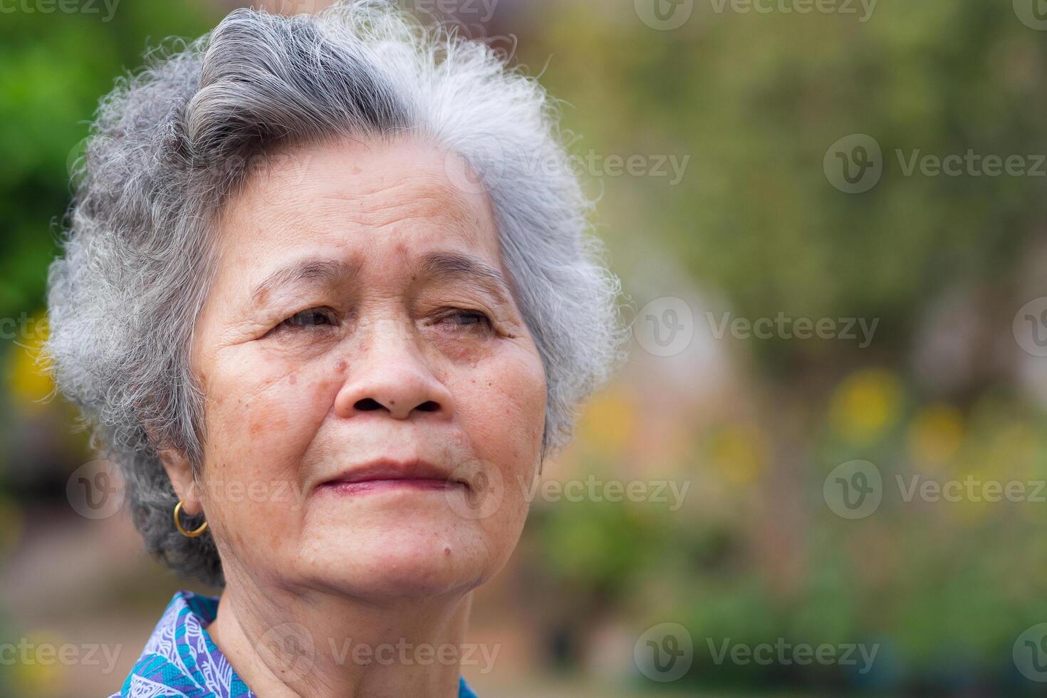 Portrait of elderly woman with short white hair and standing smile in garden. Asian senior woman healthy and have positive thoughts on life make her happy every day. Health care concept photo