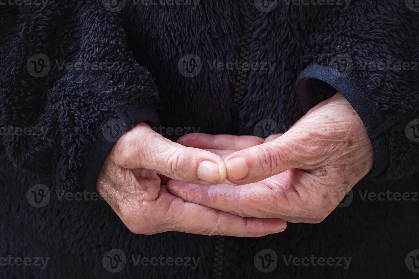 Close-up of wrinkled hands senior woman joined together for meditation. Concept of aged people and religion photo