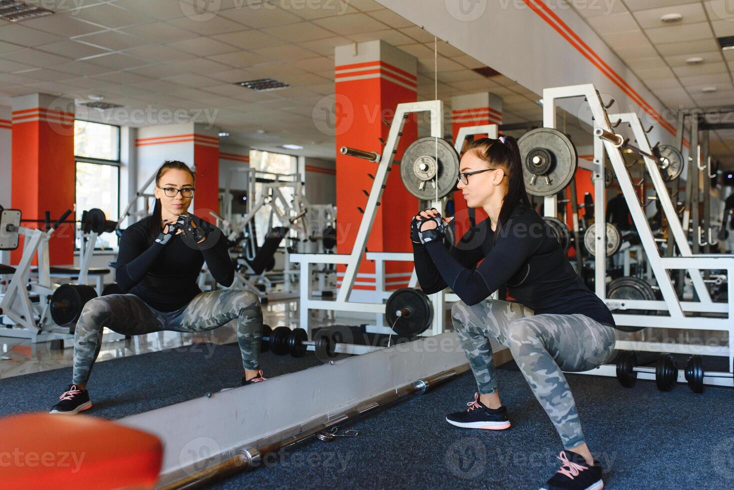 pretty girl doing stretching exercises on the floor at the gym. photo