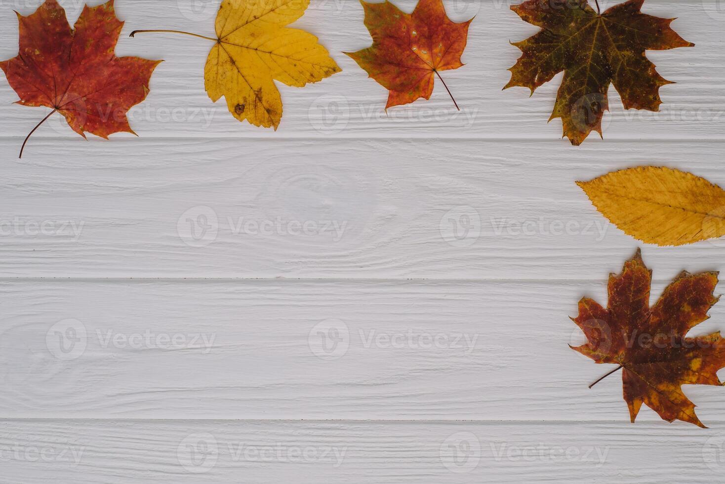 Background texture with old wooden table and yellow autumnal leaves. Autumn maple leaves on wooden background with copy space. Top view. photo