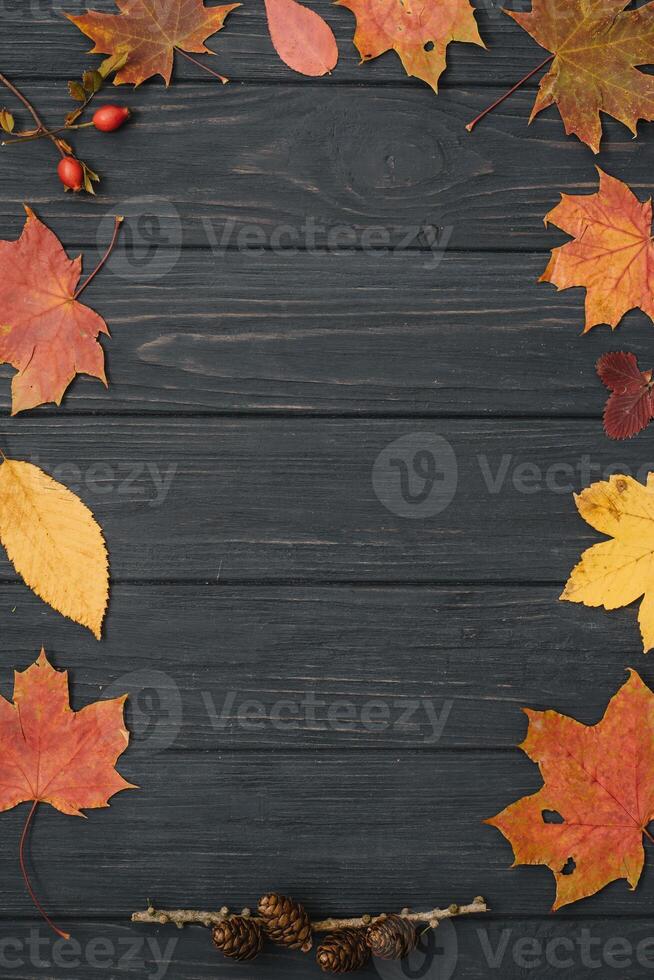 Background texture with old wooden table and yellow autumnal leaves. Autumn maple leaves on wooden background with copy space. Top view. photo