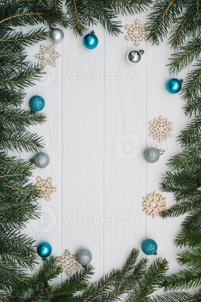 Christmas fir tree with decoration and glitters on wooden background. Christmas background on the white wooden desk photo