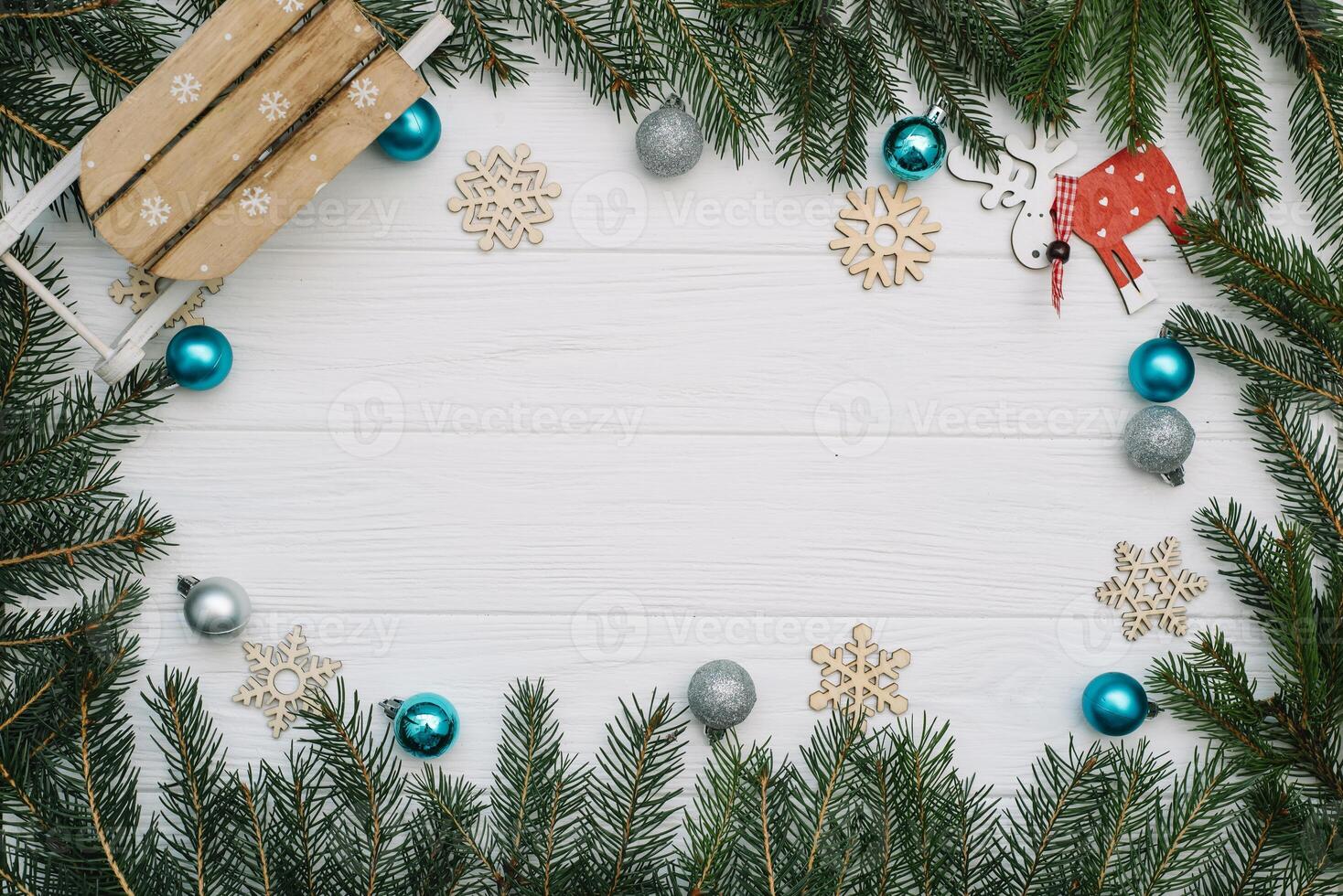Christmas fir tree with decoration and glitters on wooden background. Christmas background on the white wooden desk photo