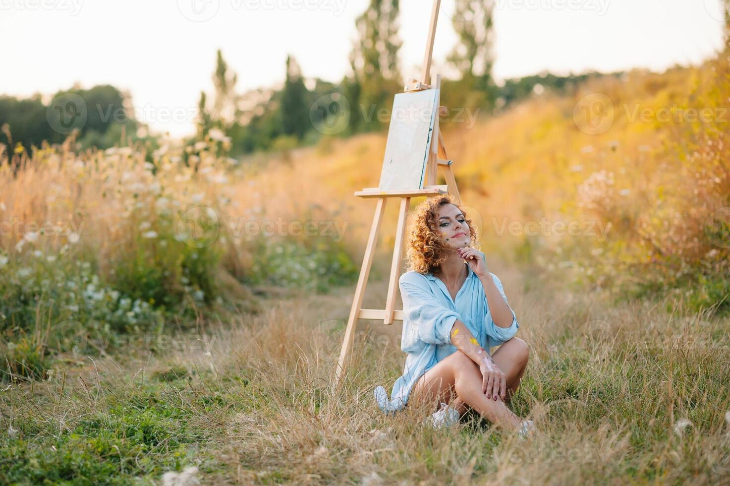 Pretty talented female painter painting on easel, making colorful sketches, creating marine landscape. Beautiful female artist painting with watercolor paints. Creativity and imagination concept photo