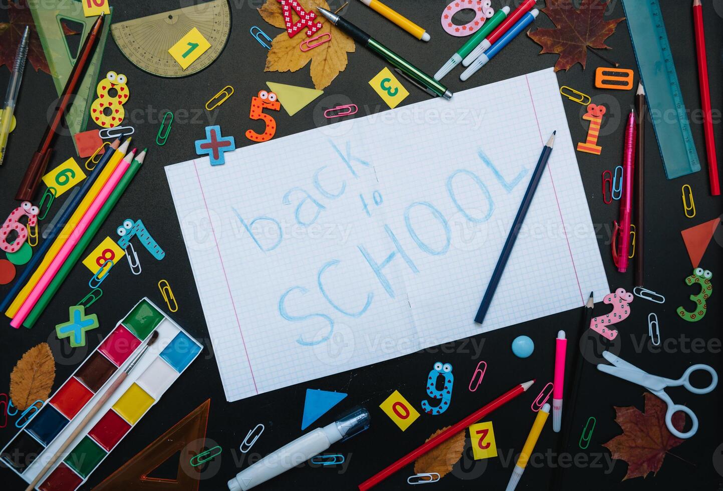 Back to school concept. School and office supplies on blackboard background photo