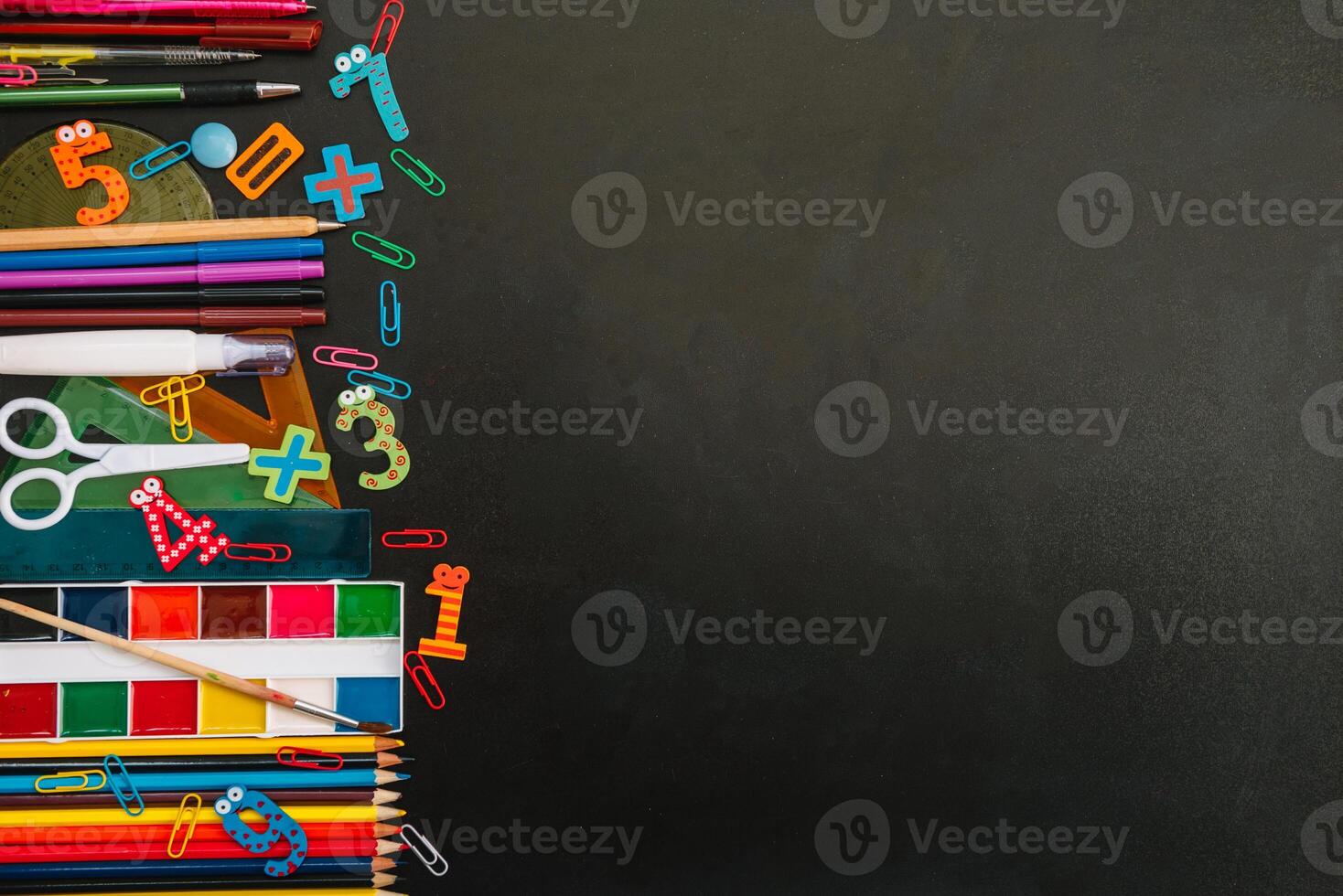 Back to school concept. School and office supplies on blackboard background. Flat lay with copy space photo