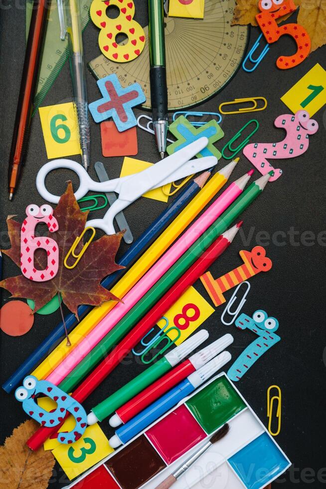 Back to school concept. School and office supplies on blackboard background. Flat lay with copy space photo